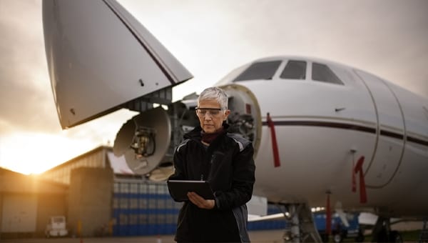 person on tablet in front of plane