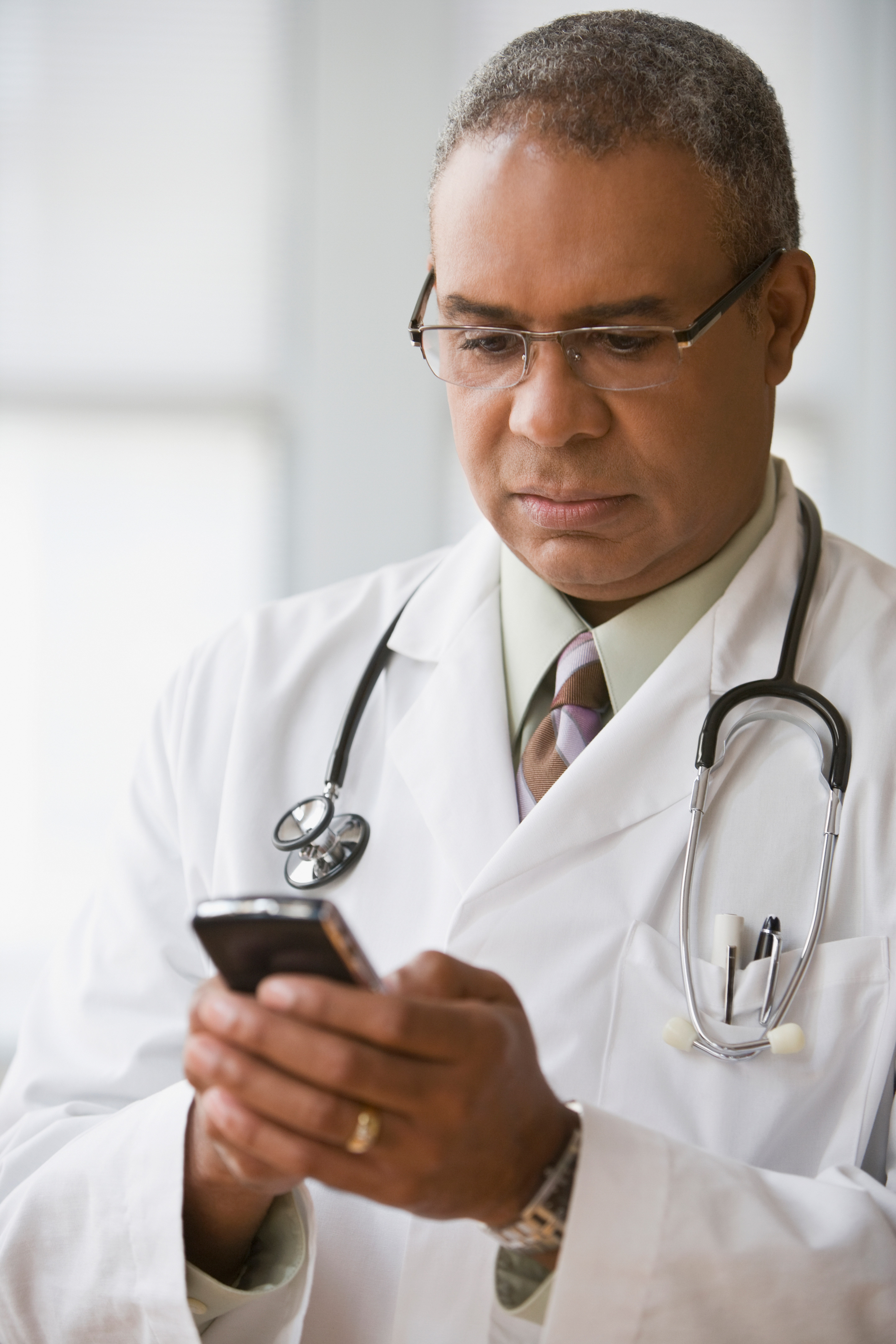 A doctor manages expenses on his phone