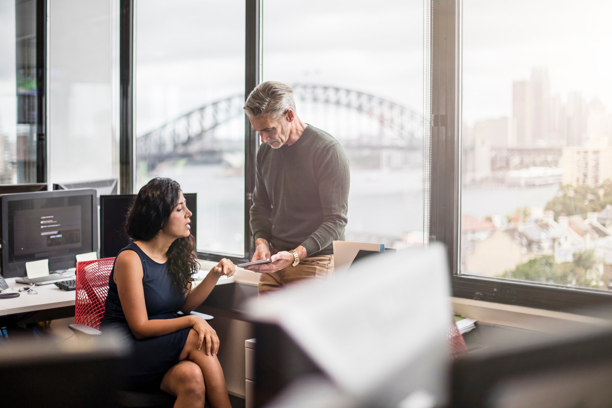 Two people in an office overlooking a city