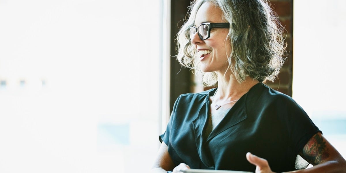 A woman in a dark top looking at her tablet computer
