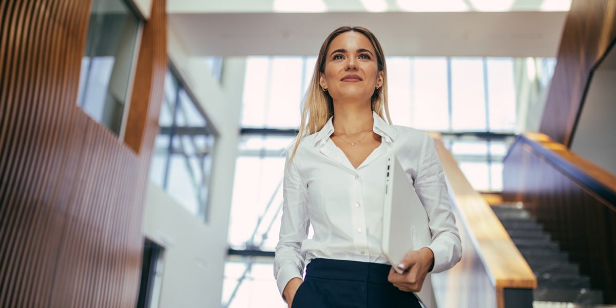 woman walking down office hallway smiling