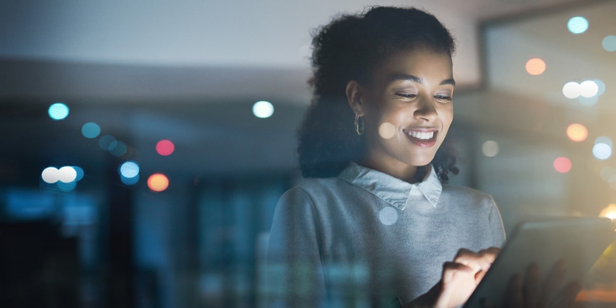 woman smiling at tablet