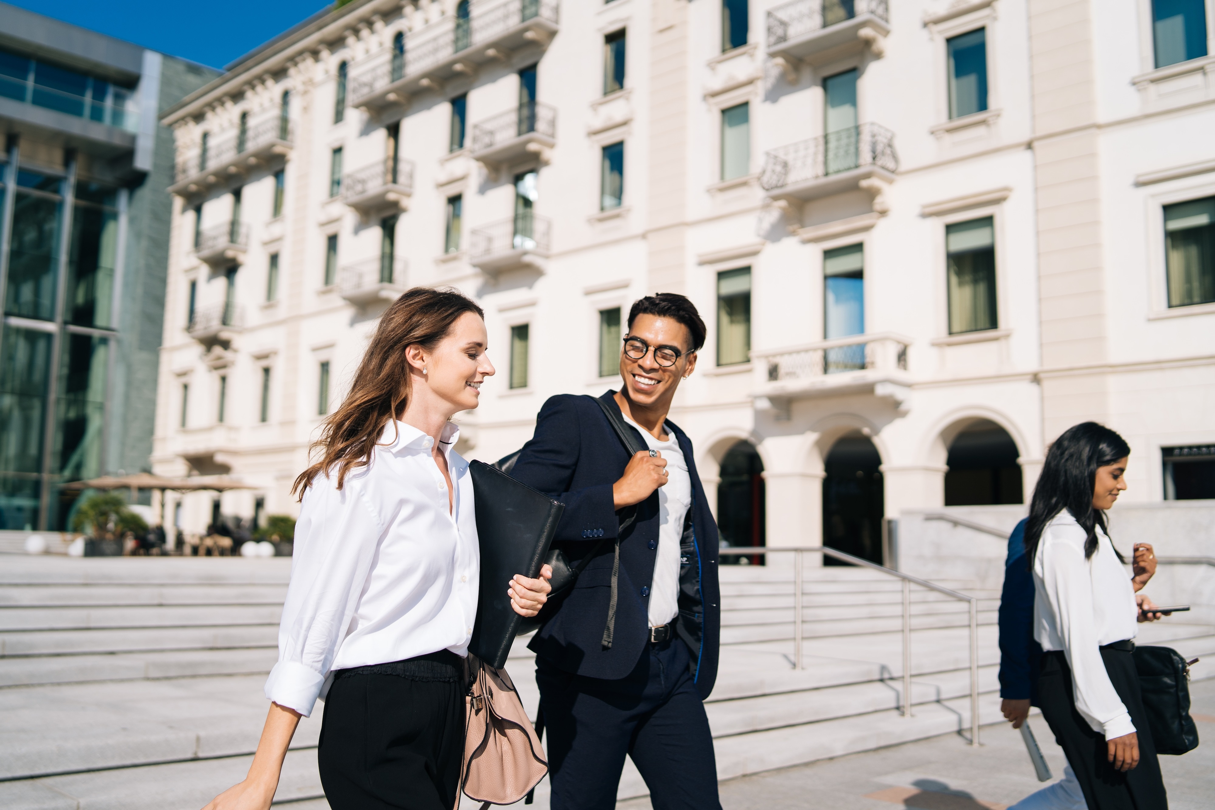 Two people walking outside government building