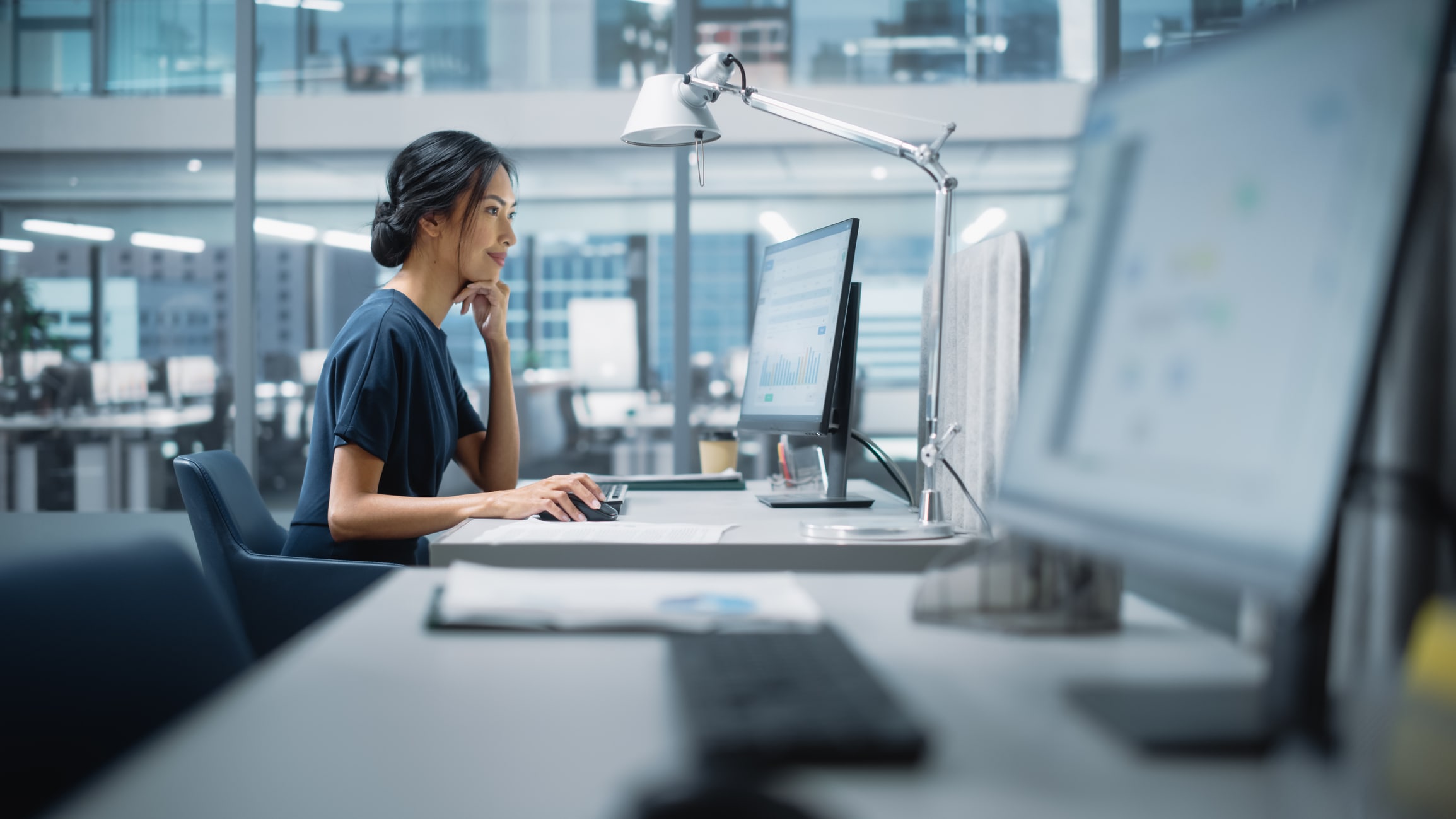 Woman sitting at computer looking at data