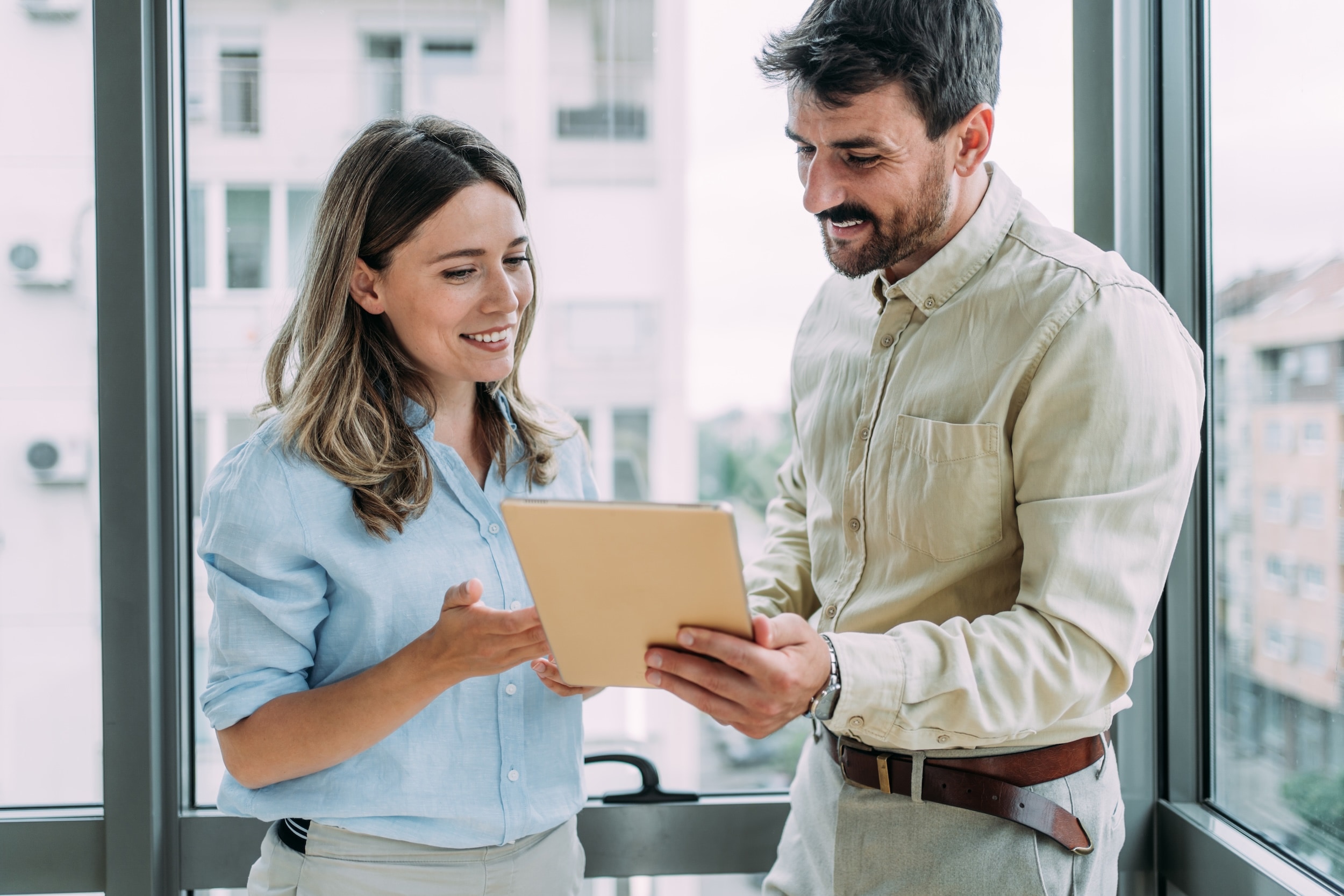 A man and a lady looking at an iPad in an office