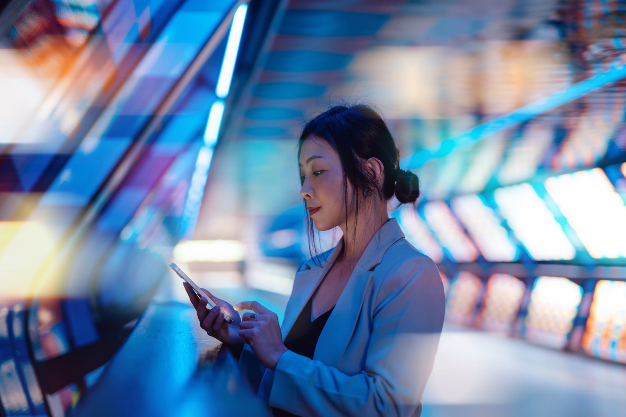 Woman in a colorful tech environment looking at her phone