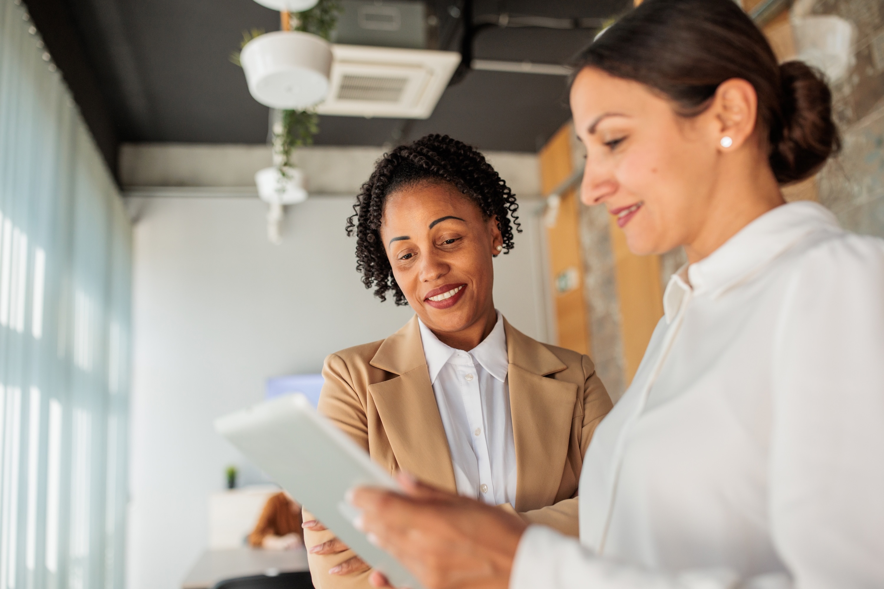 Two women reading an ipad in the office