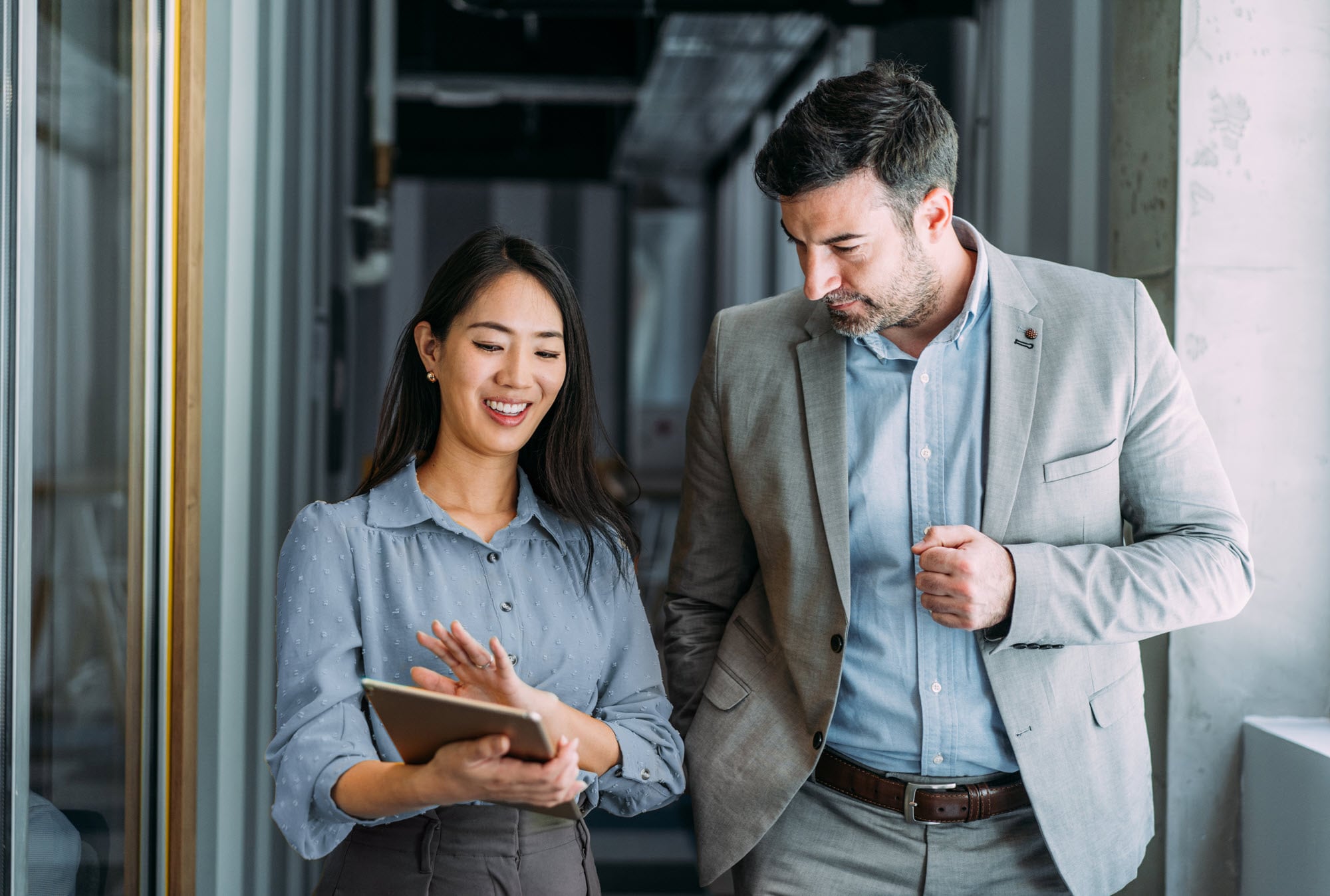 woman holding tablet talking with man