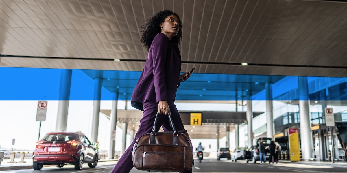 Woman in purple suit walking holding a briefcase