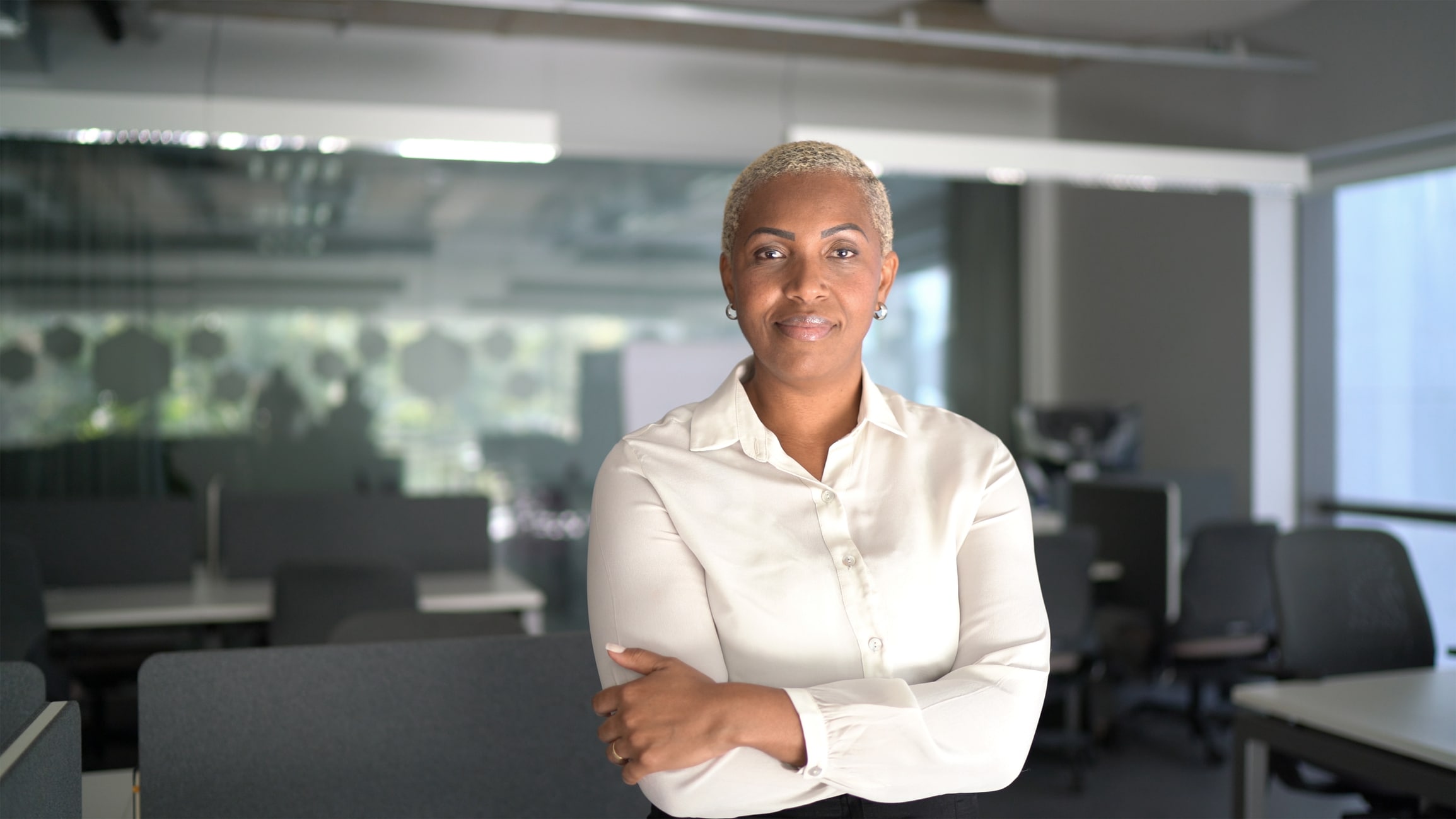 Woman standing in office looking at the camera soft smiling