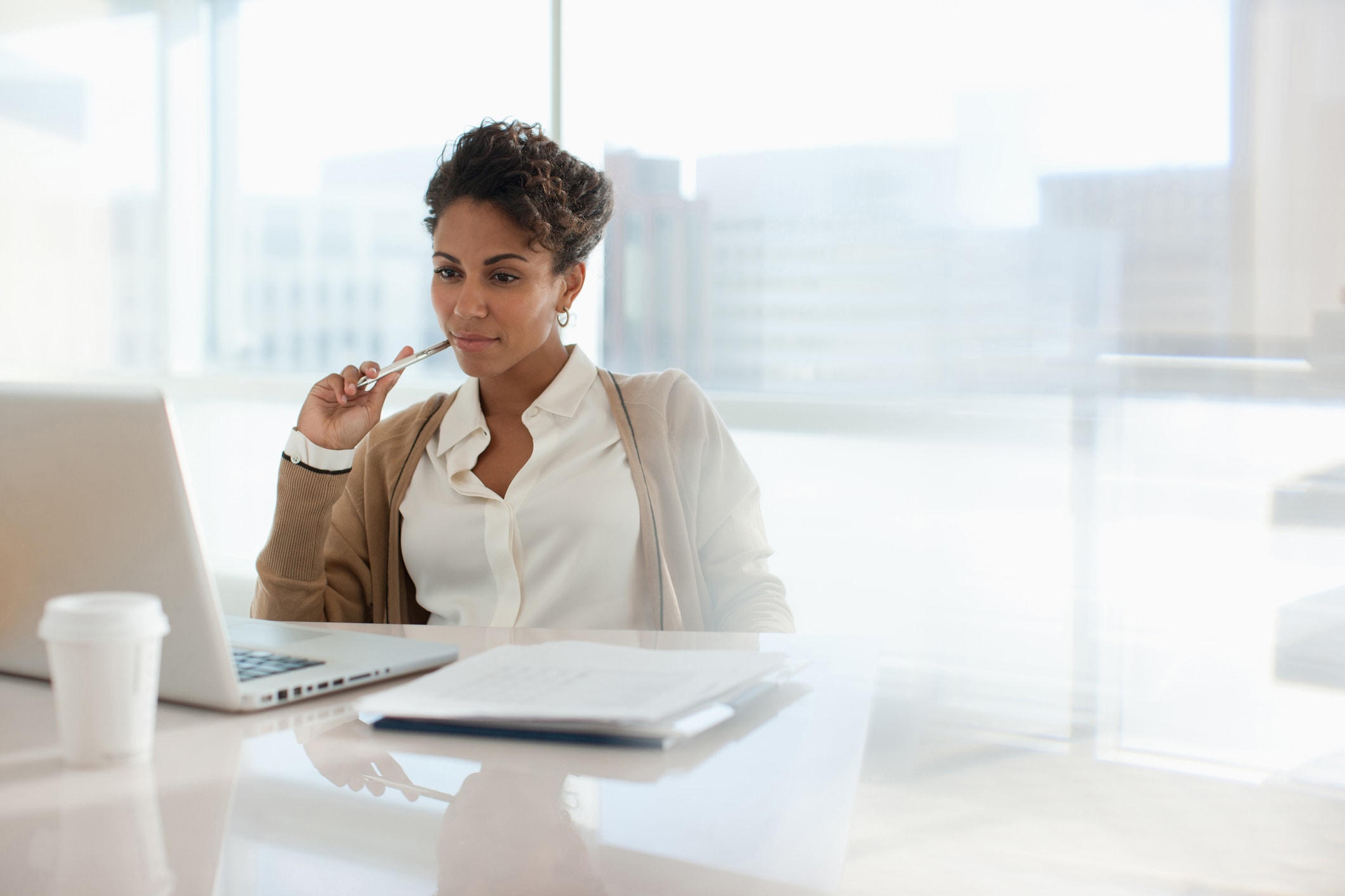 Woman sitting at desk looking at a computer