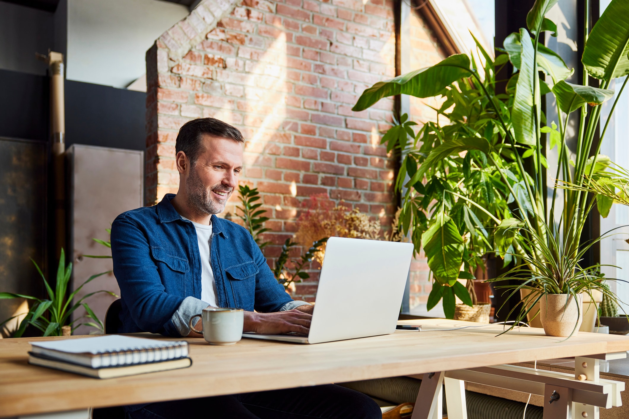 Man smiling sitting at a desk looking at his computer