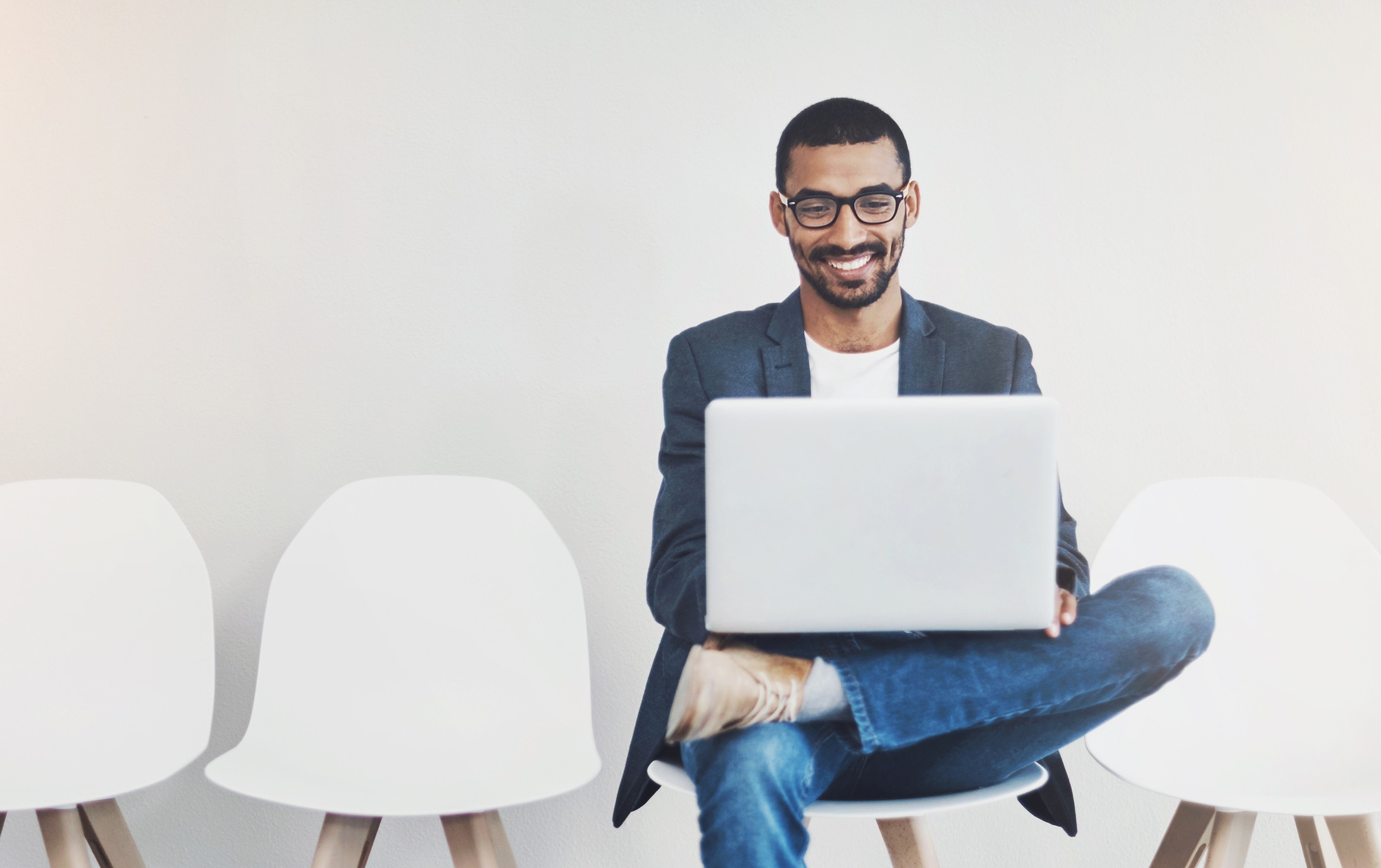 Man sitting in chair looking at laptop