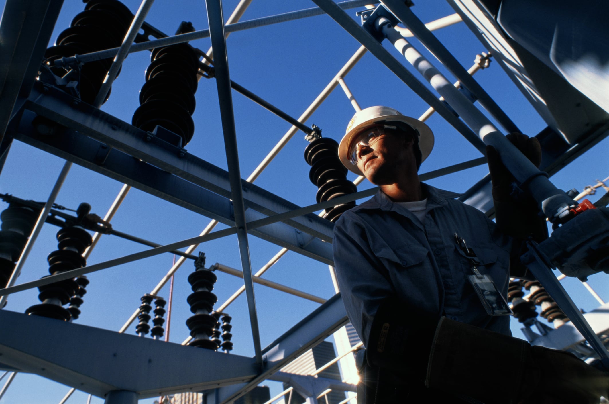 Man on a utility pole looking into the distance