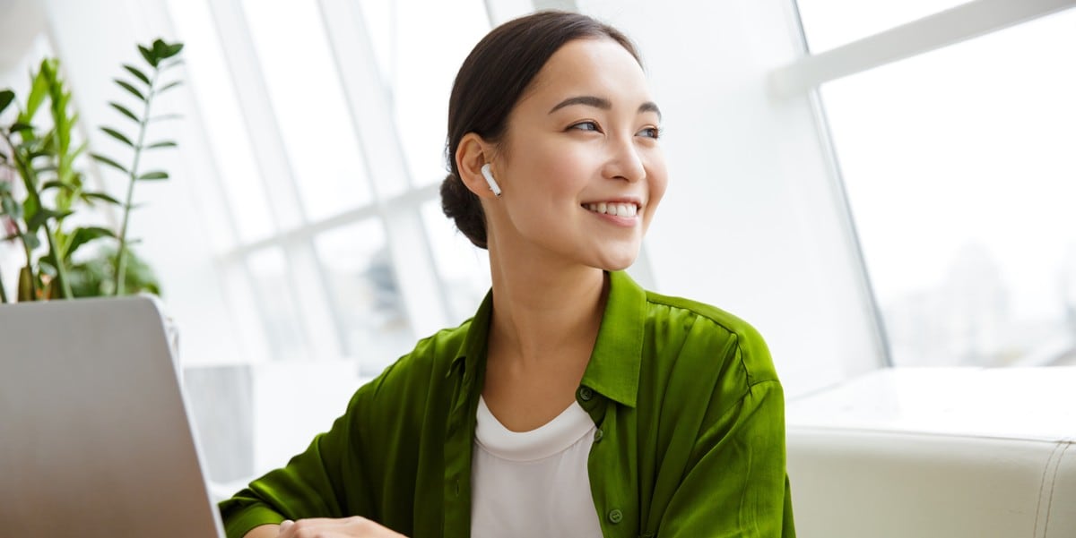 woman in green blazer at laptop