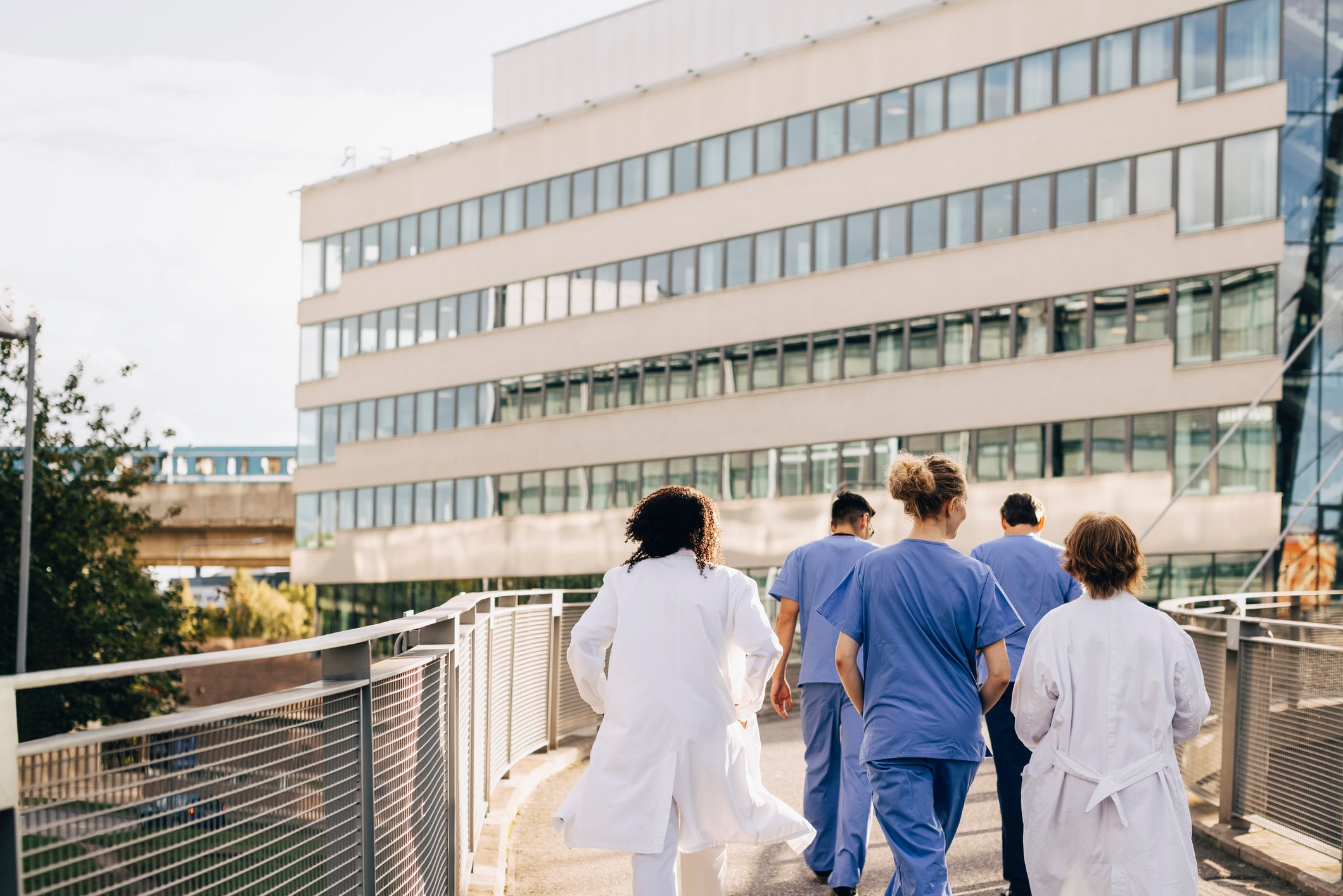 Group of healthcare professionals walking towards a hospital outside