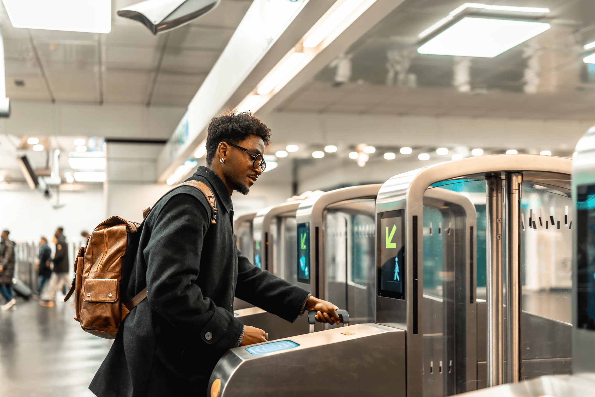Man with a suitcase passing through a ticket door with a suitcase