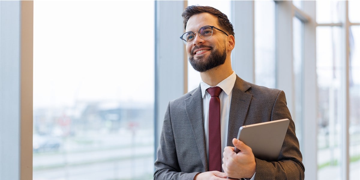 a finance leader smiles confidently while holding a tablet