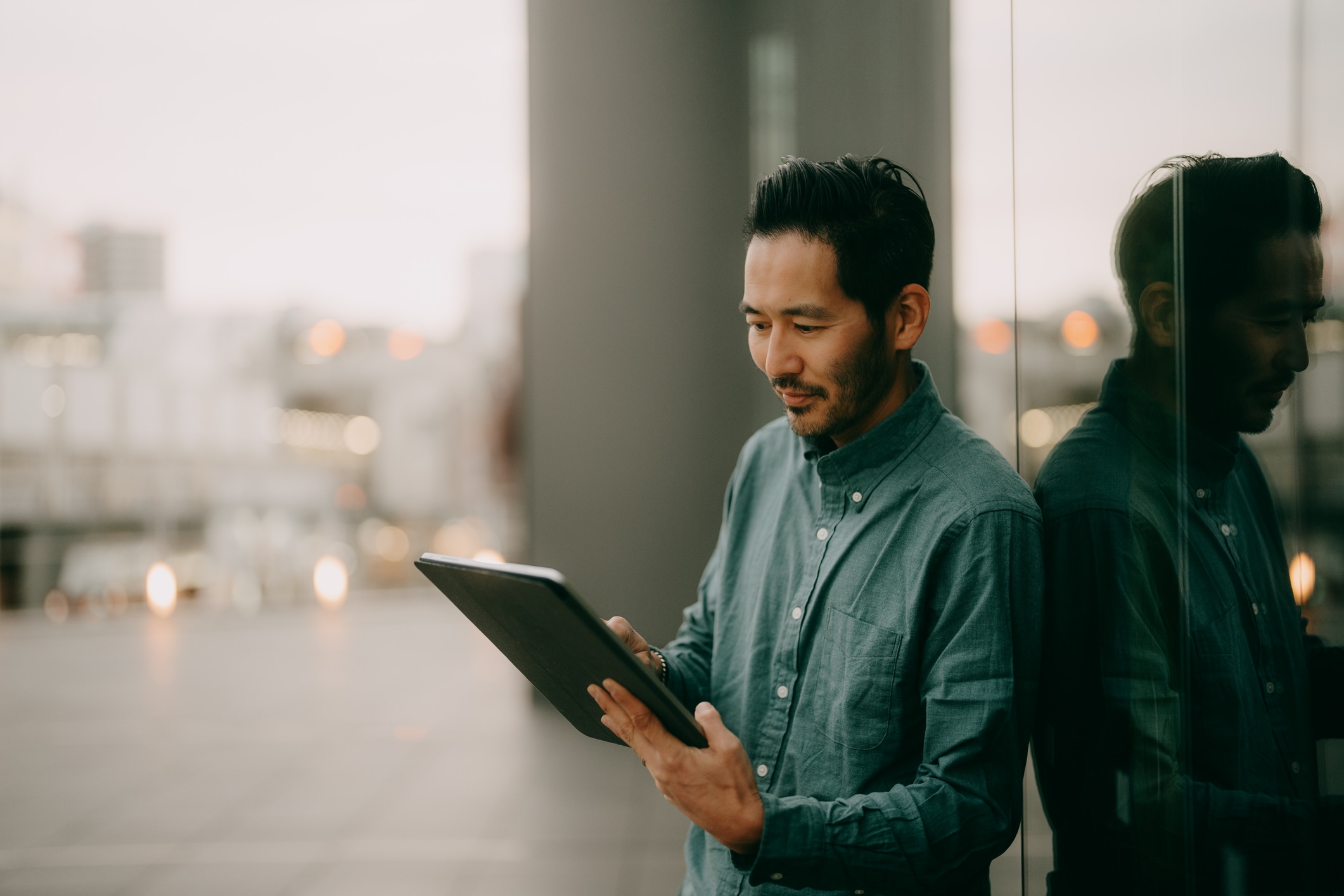 Man standing outside looking at a tablet