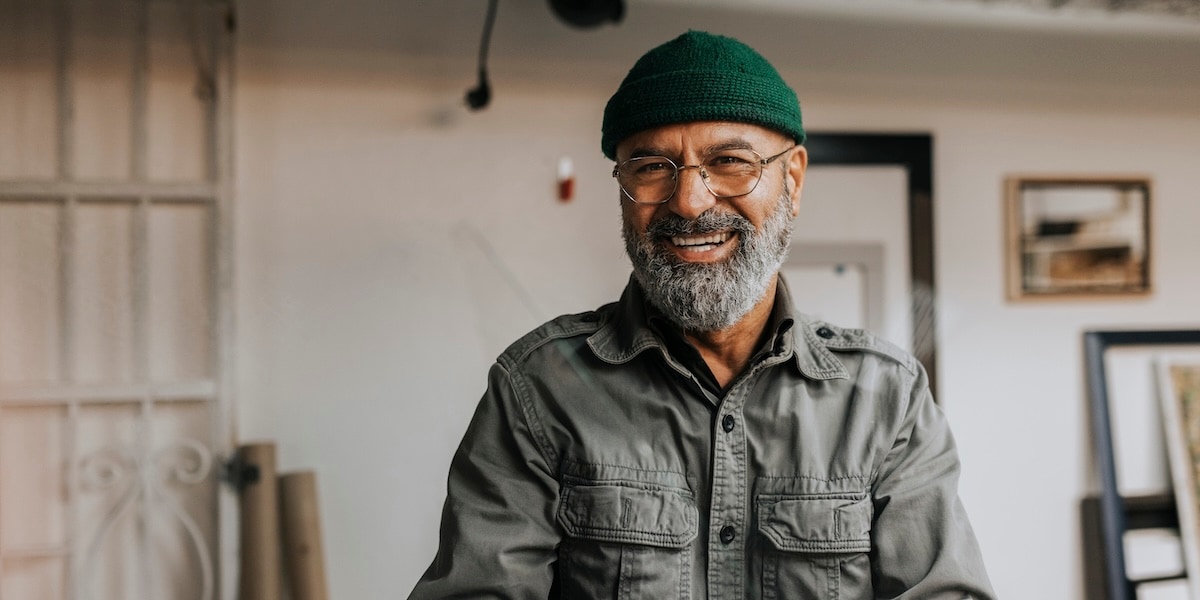 Man in green beanie smiling at camera