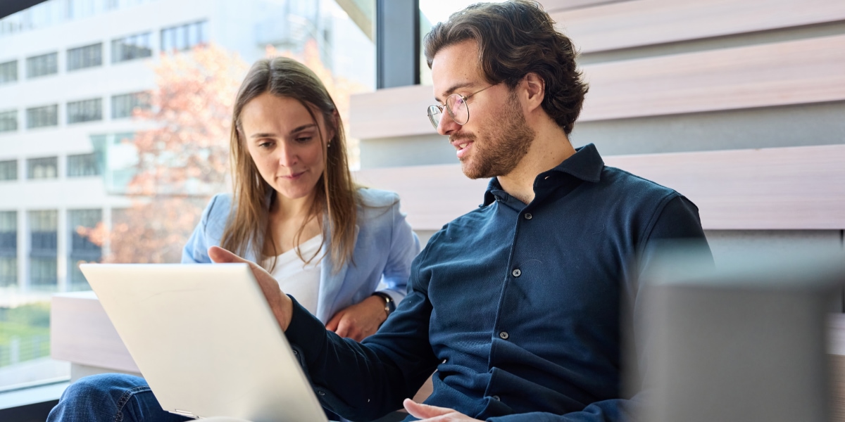 2 employees review T&E dashboard in the office