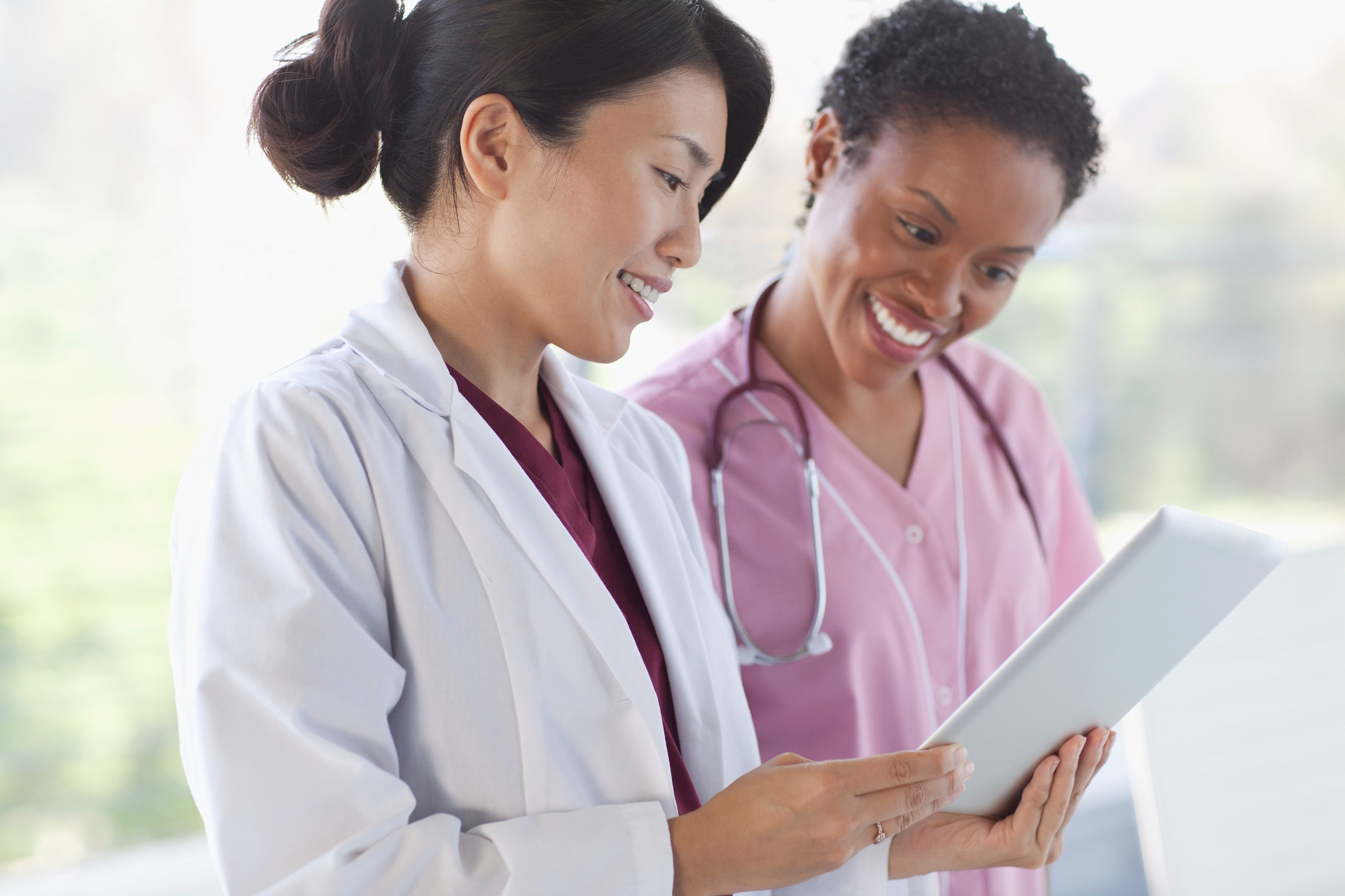 A doctor and a nurse looking at an iPad