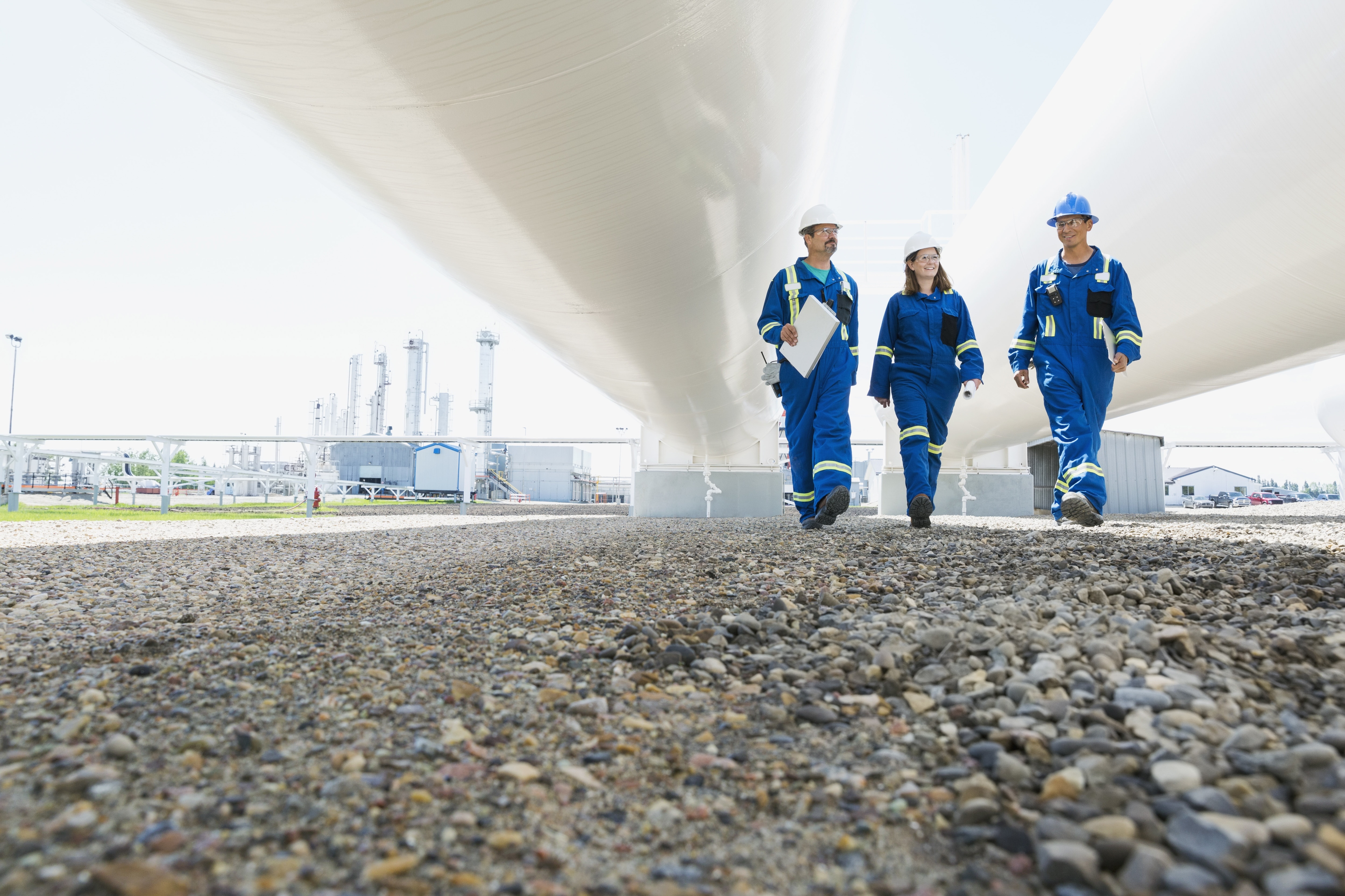 3 utilities workers walking under a bridge