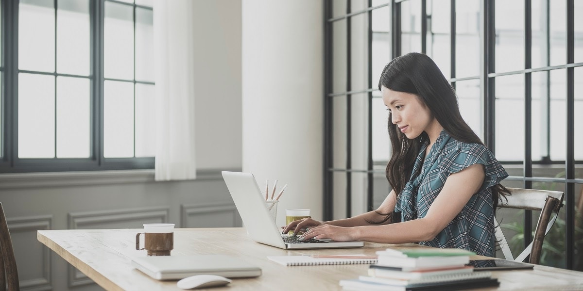 A woman working on a laptop in an office setting
