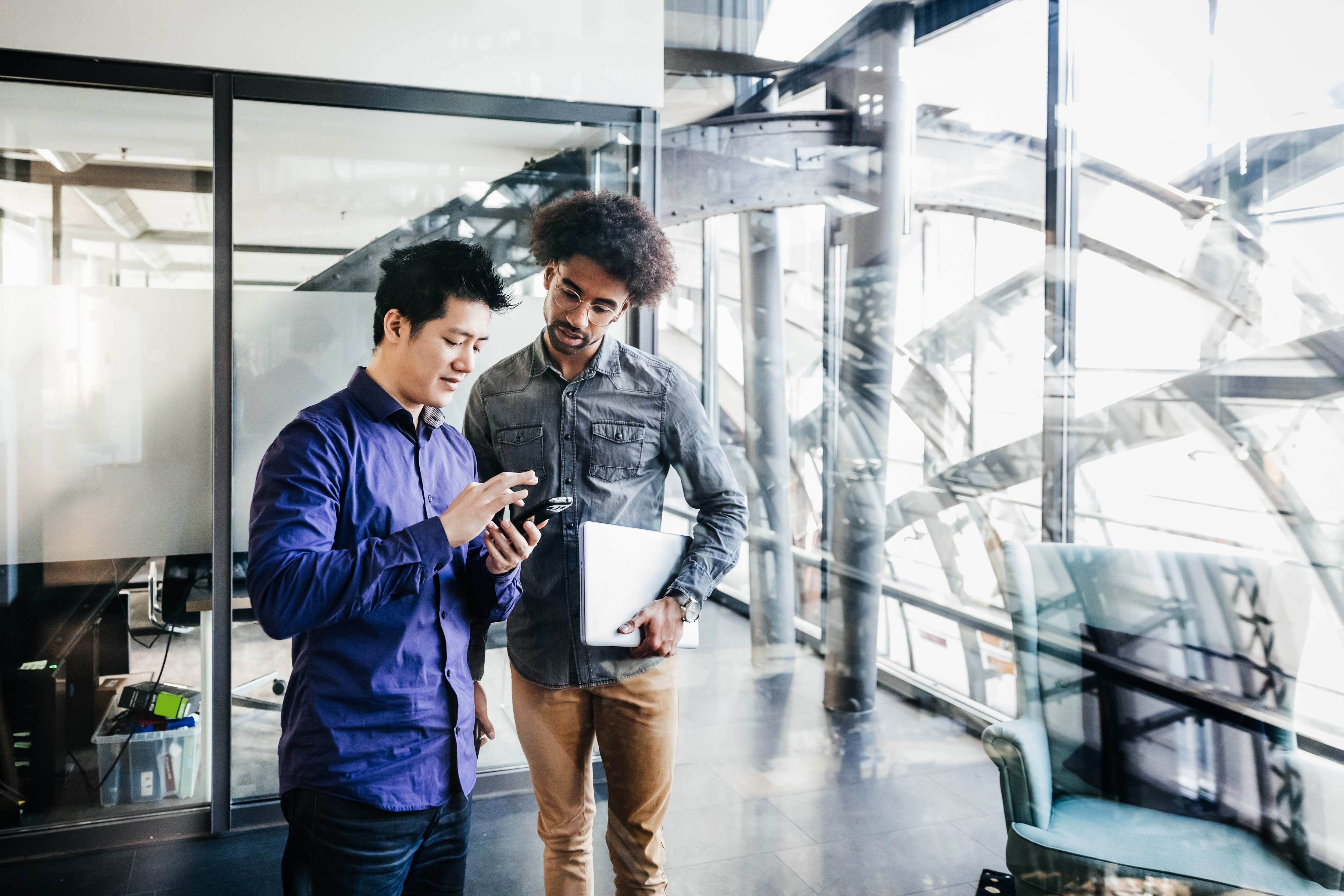 Two people in an office looking at a tablet