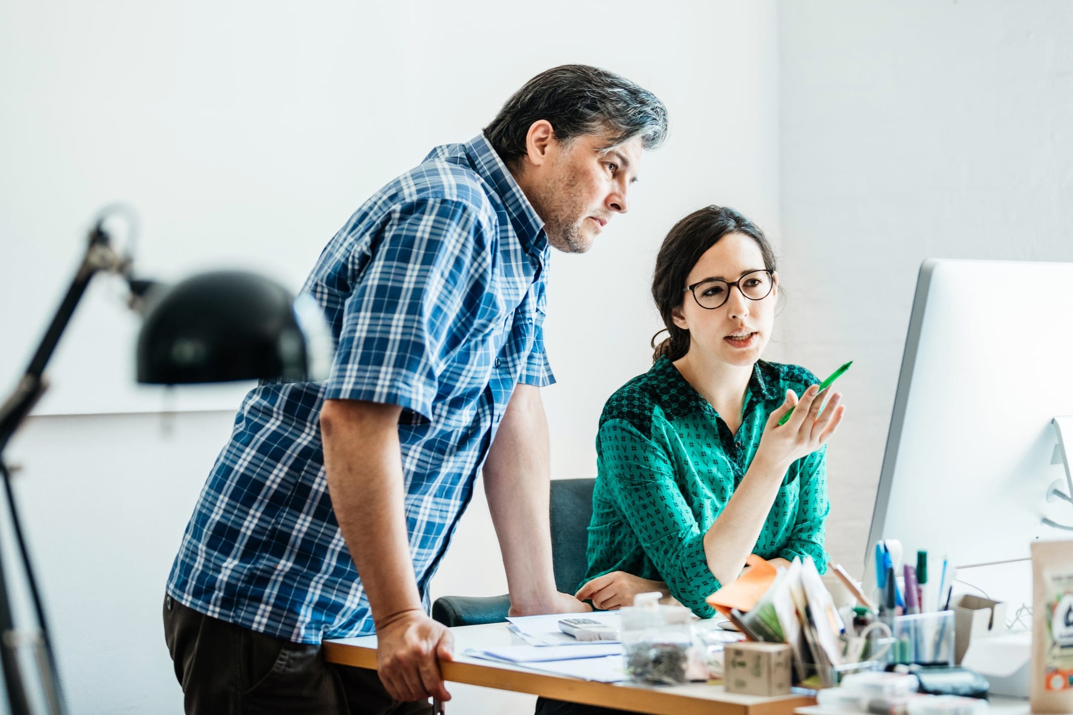 Man and woman at desk looking at a computer 