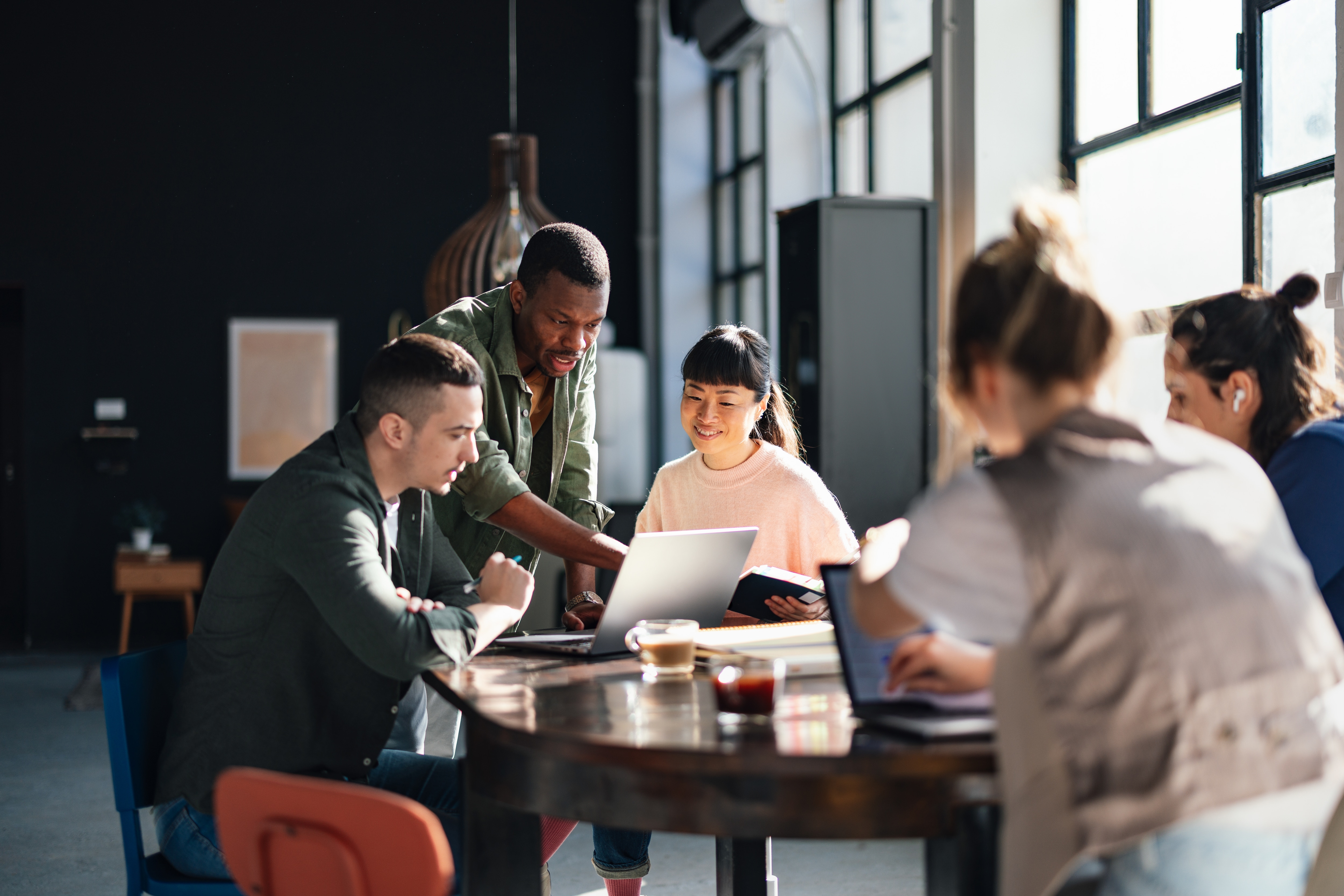 Group of people in an office looking at a computer