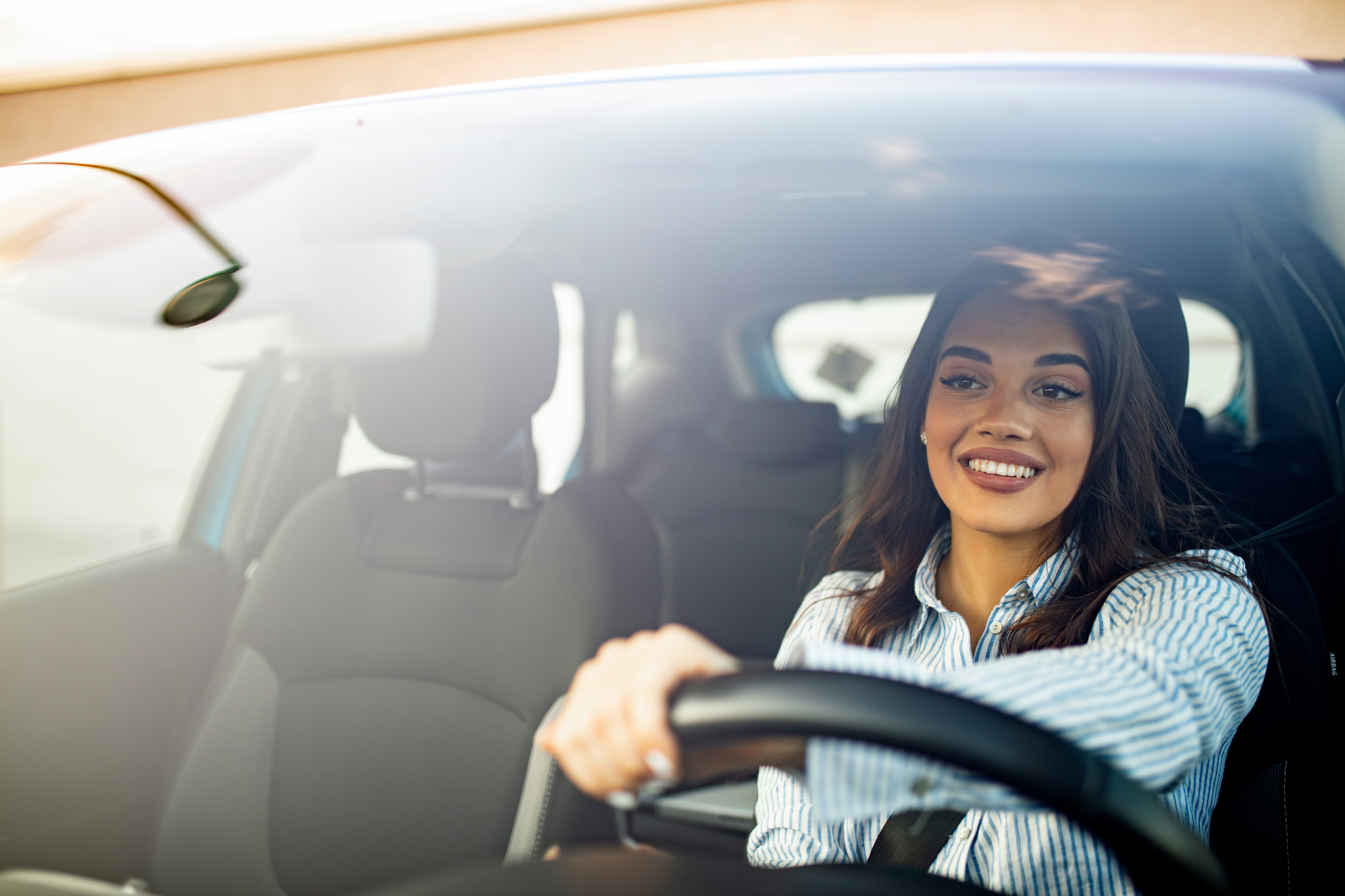 Woman driving in car with her hand on the wheel