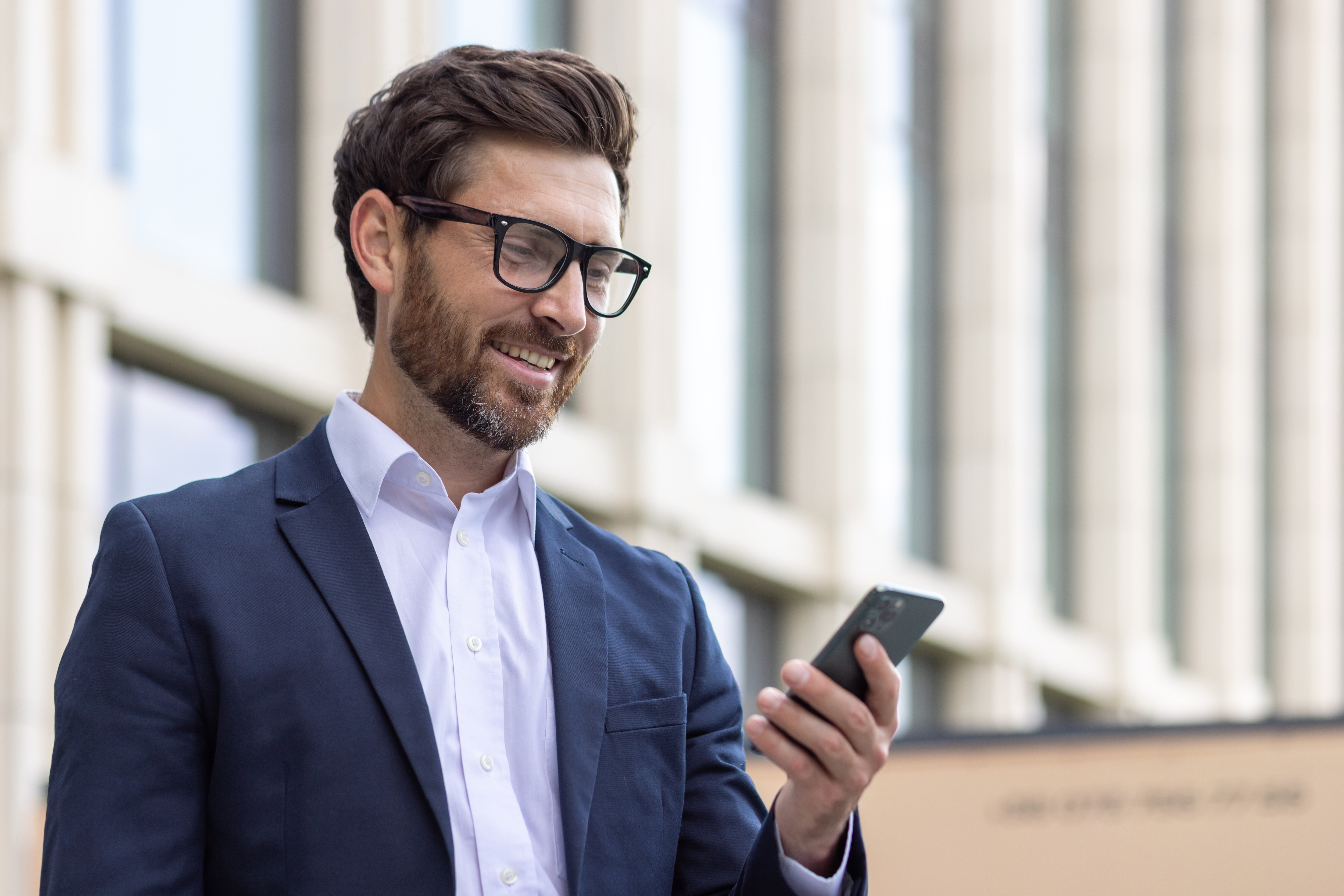 Man in suit reading his phone outside government building