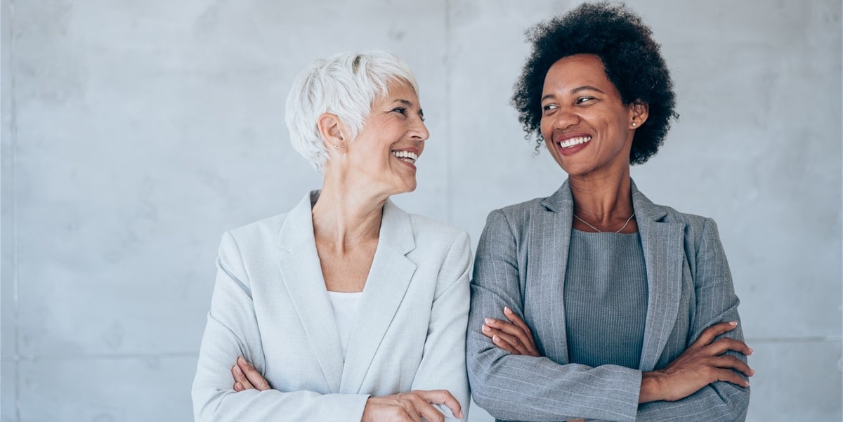 Two older professional women laughing
