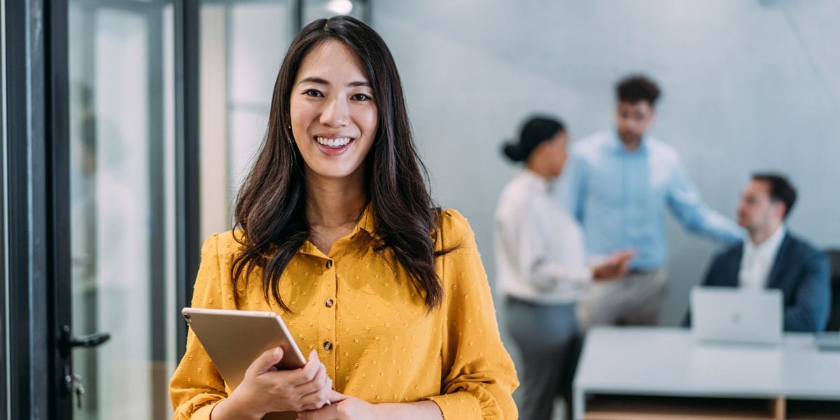woman in orange shirt holding tablet