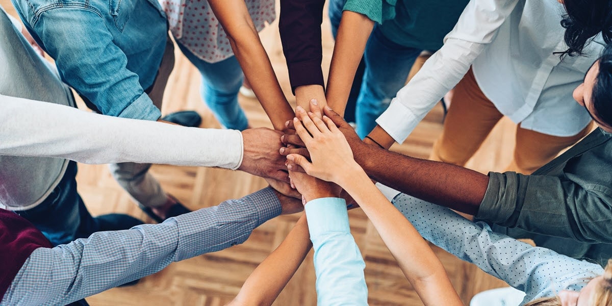 multiple hands coming together