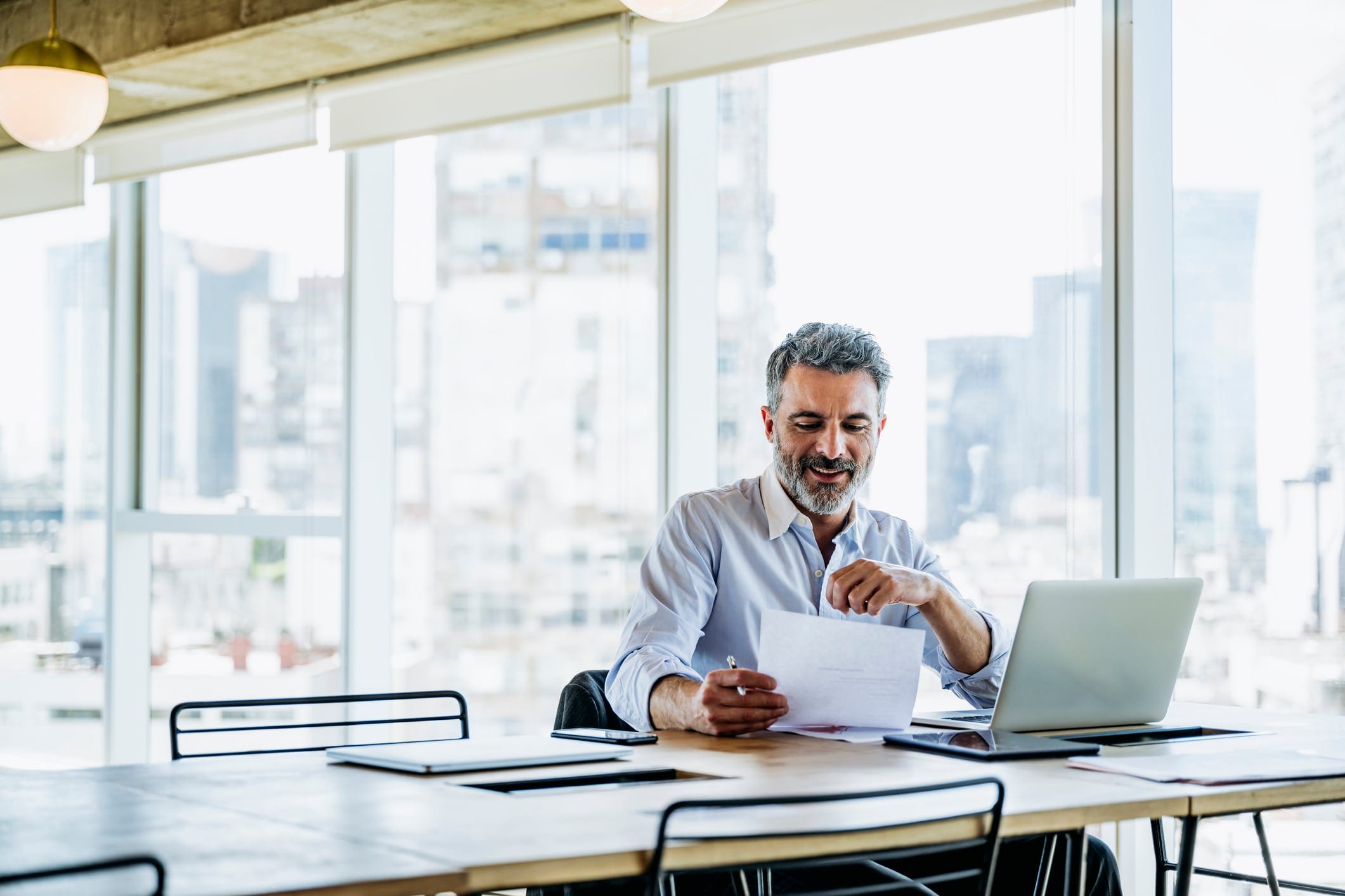 Man sitting at desk looking at printed reports