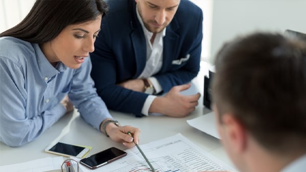 group of people look at papers at work