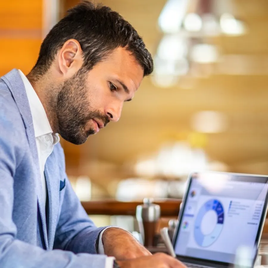 man working with charts on laptop