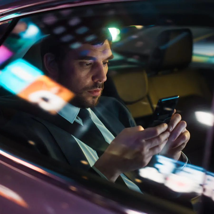 man working while riding in car