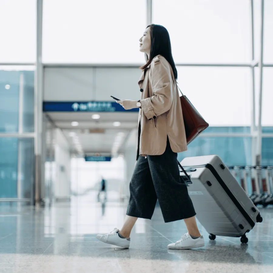 Woman wheeling luggage through an airport