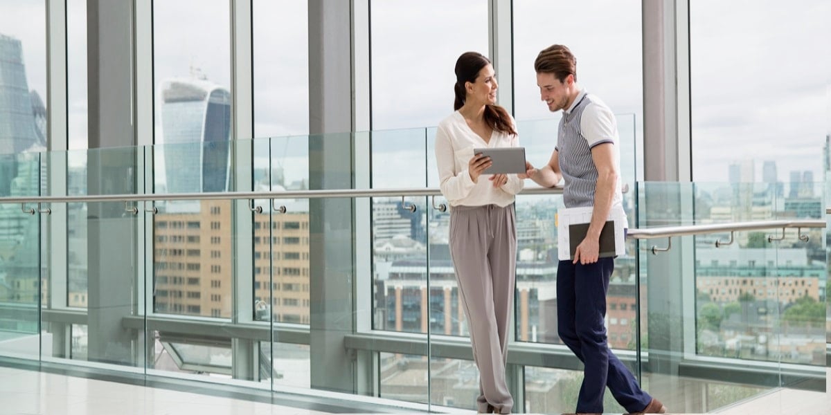 Two business people reviewing information on a tablet in an office setting
