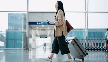 woman with luggage walking in airport
