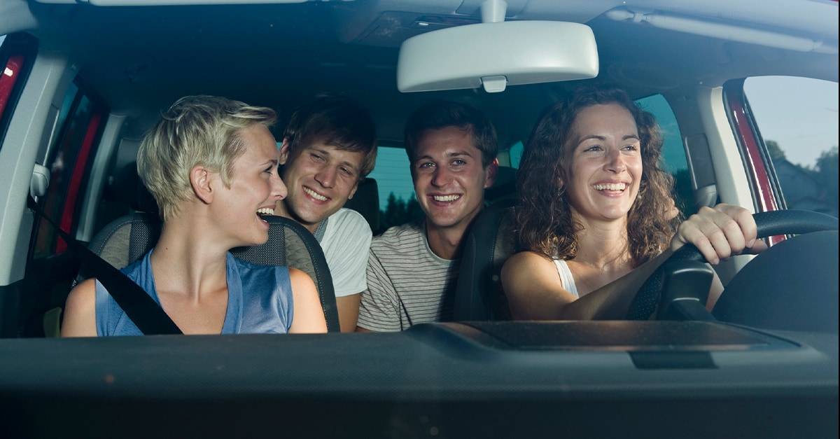 Group of happy young people in a car